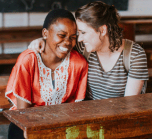 Two women sitting and bonding on a mission trip