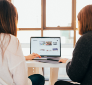 Two women looking at resources on a computer screen