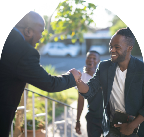 One pastor and one church goer shaking hands in front of a church